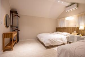 a bedroom with two beds and a mirror at GreeneStay Sindang DDP Seoul in Seoul