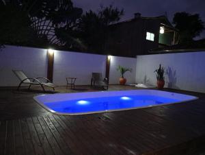 a large blue swimming pool on a patio at night at Departamento 3- Pinheira in Praia de Cima (Pinheira)