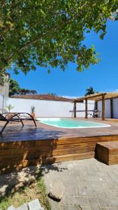 a wooden bench next to a swimming pool at Departamento 3- Pinheira in Praia de Cima (Pinheira)