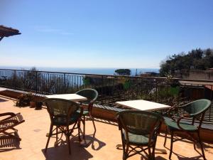 a patio with tables and chairs and the ocean at Belvedere Piano di Sorrento in Piano di Sorrento