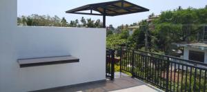 a balcony with a bench and an umbrella at Mirissa Cocoon in Mirissa