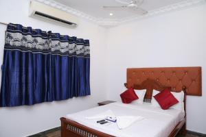 a bedroom with a bed and a blue curtain at Villa Serenity Le Sejour Pondicherry in Kottakupam +75 photos
