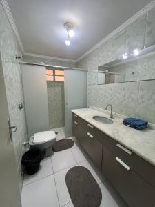 un bagno con un water, un lavandino e uno specchio di Apê Espaçoso 3 Qtos no coração da cidade a Ribeirão Preto Altre 27 foto