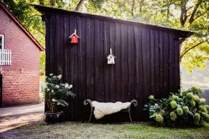 a black shed with a bench in front of it at Carpe Deimern in der Lüneburger Heide in Soltau