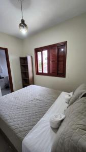a large bed in a bedroom with a window at Departamento 3- Pinheira in Praia de Cima (Pinheira) +7 photos