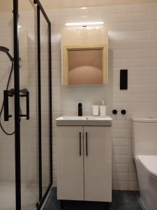 a white bathroom with a sink and a shower at Apartamenty KDN Garden in Bielsko-Biała +33 photos