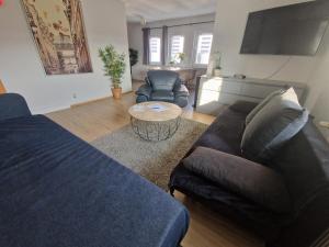 una sala de estar con un sofá y una mesa en Wohnen auf Zeit Hagen Monteurunterkunft & Übergangswohnungen, en Hagen