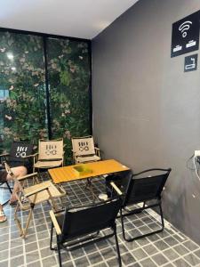 a table and chairs in a room with a window at Hood Pattaya in Pattaya