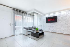 a living room with a couch and a tv on a brick wall at Triplex cosy à 20min des Champs Elysées in Gennevilliers