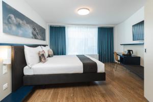 una camera da letto con un grande letto con tende blu di Hotel Bristol Zurich a Zurigo