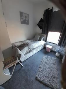 a bedroom with a bed and a window and a rug at Blaney house 21 in Newcastle upon Tyne