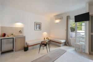 a living room with a small table and a kitchen at Irini's Poiēma in Lefkes +24 photos