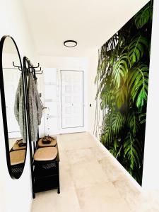 a bathroom with a mirror and a plant mural at Villa Margarita ocean view and private heated pool in Adeje