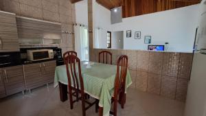 a kitchen with a table with chairs and a microwave at Casa espaçosa e acolhedora SFX in São Francisco Xavier