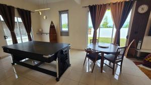 a dining room with a ping pong table and a table and chairs at Villa 63 3Bedroom 8pax in Beranang