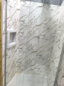 a bathroom with a marble shower with a glass door at Suíte Canto do Mar in Barra Grande