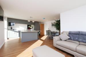 a living room with a couch and a kitchen at Swift Apartments York in York