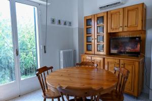 a dining room with a wooden table and a tv at 'Largo Dei Sapori House' in Alberobello
