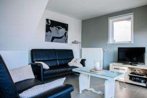 a living room with a couch and a table at Vakantiewoning Zee & Polder met tuin, dicht bij zee in Middelkerke