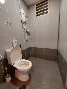 a bathroom with a toilet and a phone on the wall at Alam Sanjung Stop Centre in Shah Alam