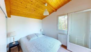a bedroom with a bed and a wooden ceiling at LYS DE NOJALS - Superbe villa familiale entre lac et mer avec jardin in Soorts-Hossegor