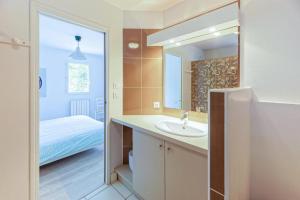 a bathroom with a sink and a bed and a mirror at LYS DE NOJALS - Superbe villa familiale entre lac et mer avec jardin in Soorts-Hossegor +35 photos