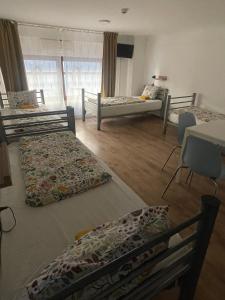 a room with four beds and a table and chairs at Center Hostel and Guest House in Budapest