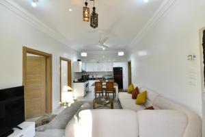 a living room with a white couch and a kitchen at Villa Luna Simone in Al Karnak
