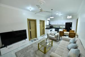 un soggiorno con divano e TV a schermo piatto di Villa Luna Simone a Al Karnak