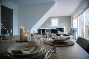 a dining room table with plates and wine glasses at Vakantiewoning Zee & Polder met tuin, dicht bij zee in Middelkerke