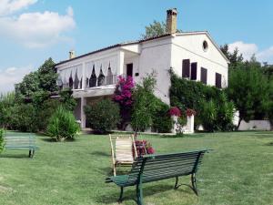 ein Gebäude mit zwei Bänken davor in der Unterkunft C'era Una Volta in Ripatransone