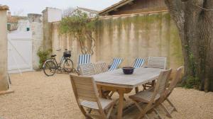 a wooden table and chairs in a backyard at Charmante Maison de village avec étage in La Couarde-sur-Mer