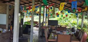 a patio with a table and some colorful flags at FAZENDA BOSQUE DAs PALMEIRAS in Itamaracá