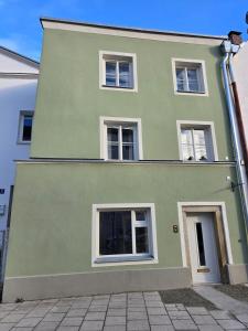 a green house with white windows on a street at Untere Vorstadt, Deggendorf in Deggendorf