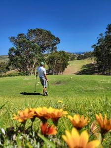 a man is standing in a field with a golf ball at Casa Monki in Raposeira