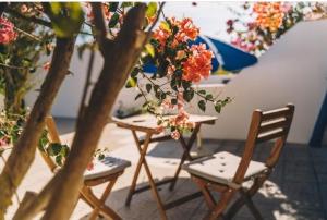 two chairs and a table with flowers on it at Casa Monki in Raposeira
