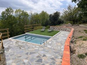 a swimming pool with two chairs and a grassy yard at Maison l ouline in Montferrer