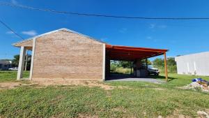 un edificio in mattoni con tetto rosso di ItuRanch II a Ituzaingó