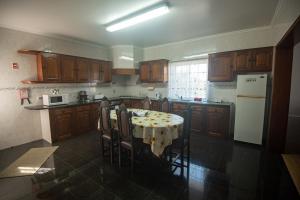 a kitchen with a table with chairs and a white refrigerator at Casa Gabriel Barbosa in Lagoa