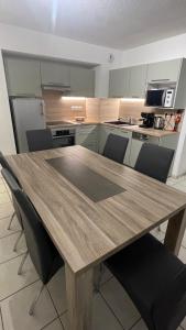 a kitchen with a wooden table and chairs at Appartement 65m² idéalement placé pour 6 pers. in Brides-les-Bains +4 photos