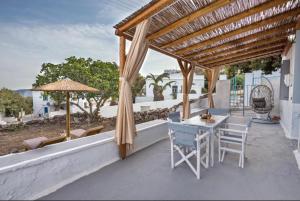 a patio with a table and chairs and an umbrella at The beautiful Plaka in Plaka Milou