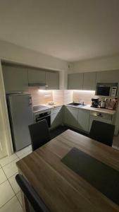 a kitchen with a table with chairs and a refrigerator at Appartement 65m² idéalement placé pour 6 pers. in Brides-les-Bains