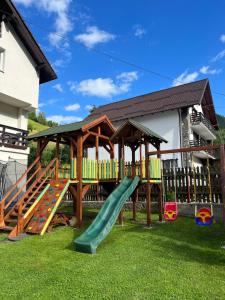 a playground with a slide and a gazebo at Casa Mia in Moieciu de Sus