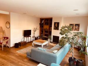 a living room with a blue couch and a table at Charming & Spacious Duplex viewing the lovely MAS in Antwerp