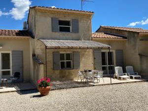 a house with a patio with a table and chairs at Gites de France du Domaine de Laforest in Fontvieille