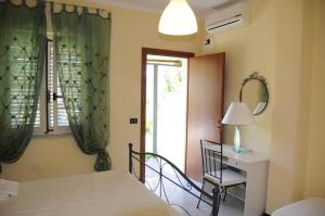 a bedroom with a bed and a desk and a window at Casa Vacanze Marcella in Palinuro