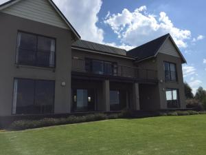 a large house with a lawn in front of it at Guest house Woodridge Forest 11 in Balgowan