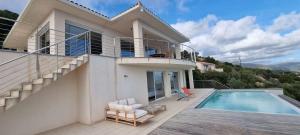 una casa con piscina y balcón en Villa de standing piscine chauffée vue mer Corse du sud, en Coti-Chiavari