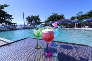 ペーニャにあるHotel Pé na Areiaのスイミングプールの隣のテーブルに座ってカクテル3杯 +183枚の写真