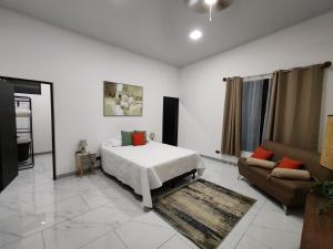 a bedroom with a bed and a couch at Casa Pacifica in Uvita +37 photos